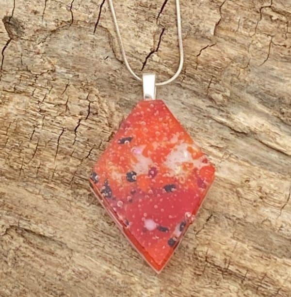 red diamond shaped pendant with white and black accents