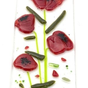 four red poppies with small red bits on a sun catcher