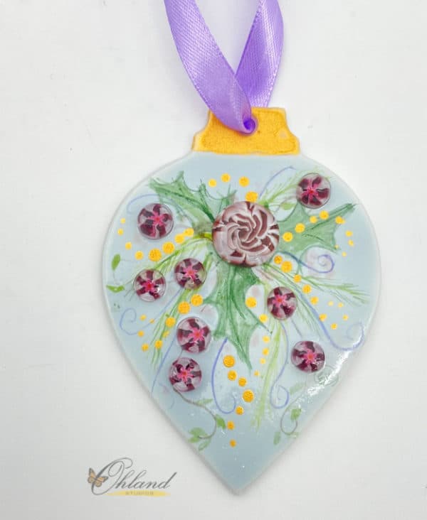 purple rose and small flowers with holly leaves on a light blue background christmas ornament