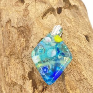 Diamond shaped glass pendant with translucent light turquoise base, dark aqua, cobalt, white and bright green bits throughout and a very shiny green/blue pice of glass, pendant has a silver bail