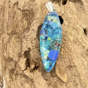 Oval with points shaped pendant with translucent turquoise background glass and a large silver bail. The pendant has flecks of glass with cobalt, turquoise and withe throughout and is very dimensional and shiny